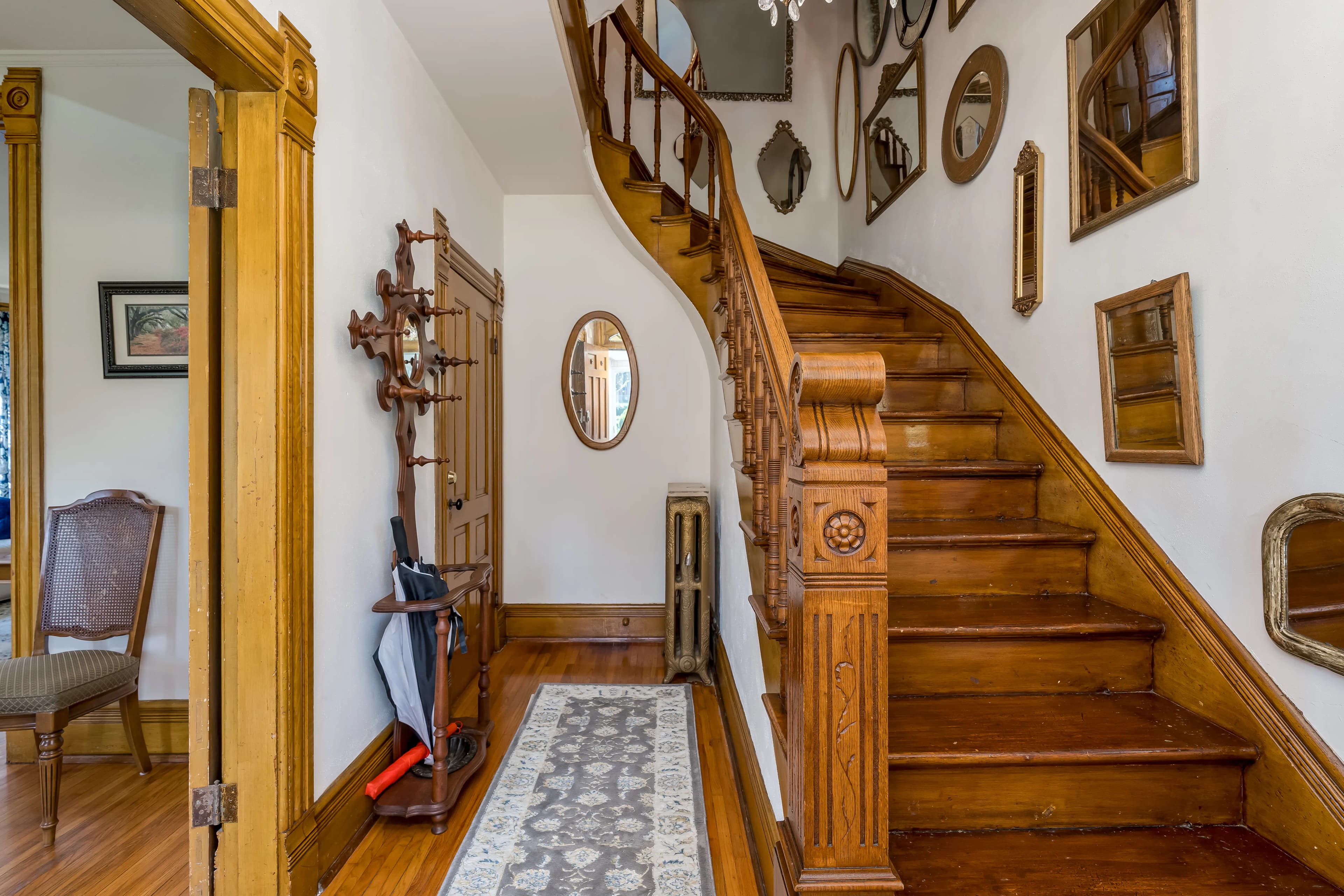 A beautiful wood staircase weaving up to a second floor with a carved banister and railings.