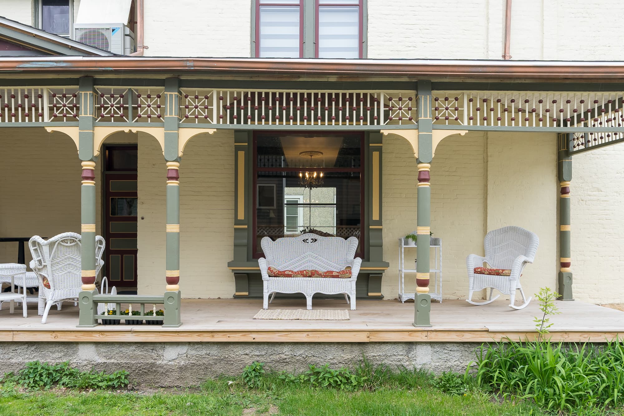 A cozy porch featuring wicker furniture and decorative columns.